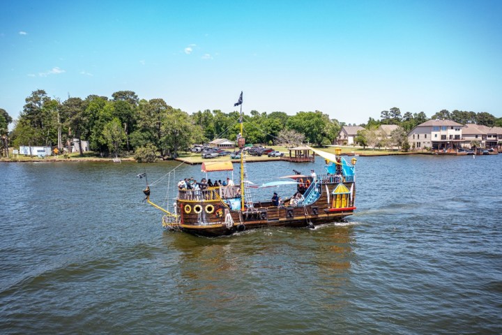 a boat floating along a river next to a body of water