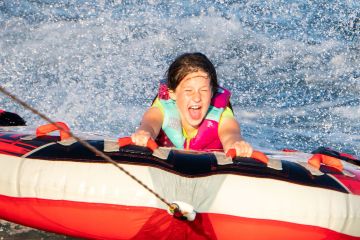 a person riding on the back of a boat in the water